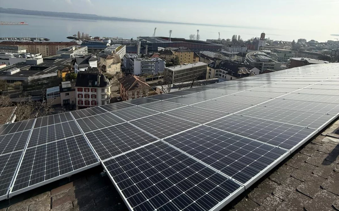 Panneaux photovoltaïques sur un toit avec vue sur Neuchâtel et le lac